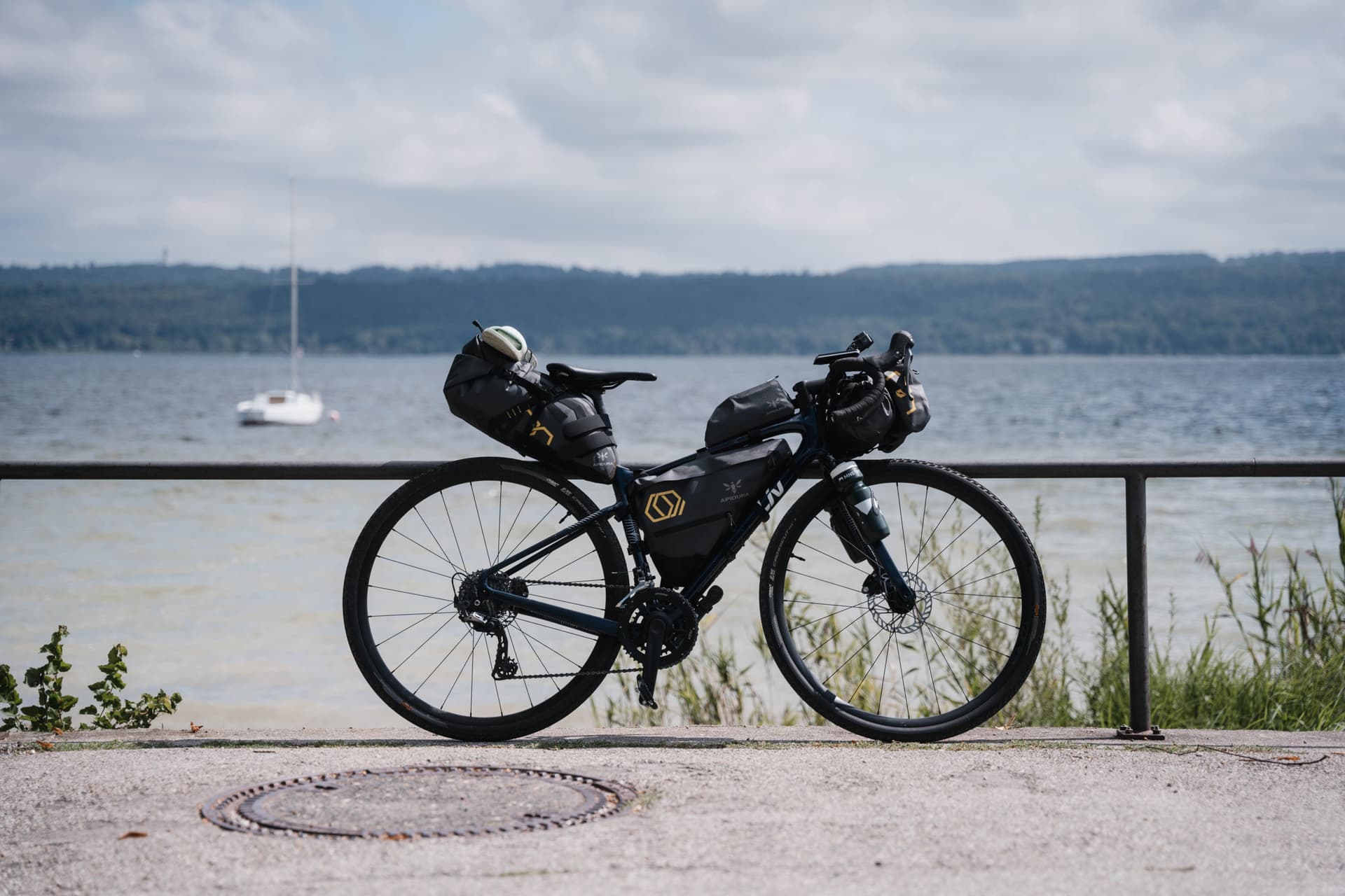 Touring bike packed with bags by a lakeside